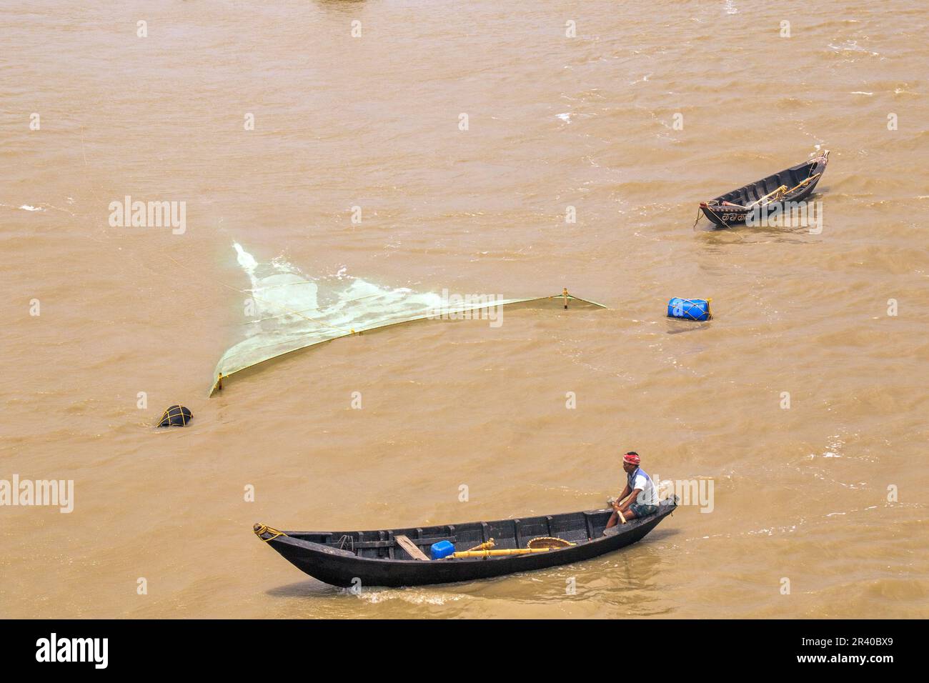 Pescatori e donne stanno lavorando per catturare gamberi nel fiume nella calda mattina di sole. Foto Stock