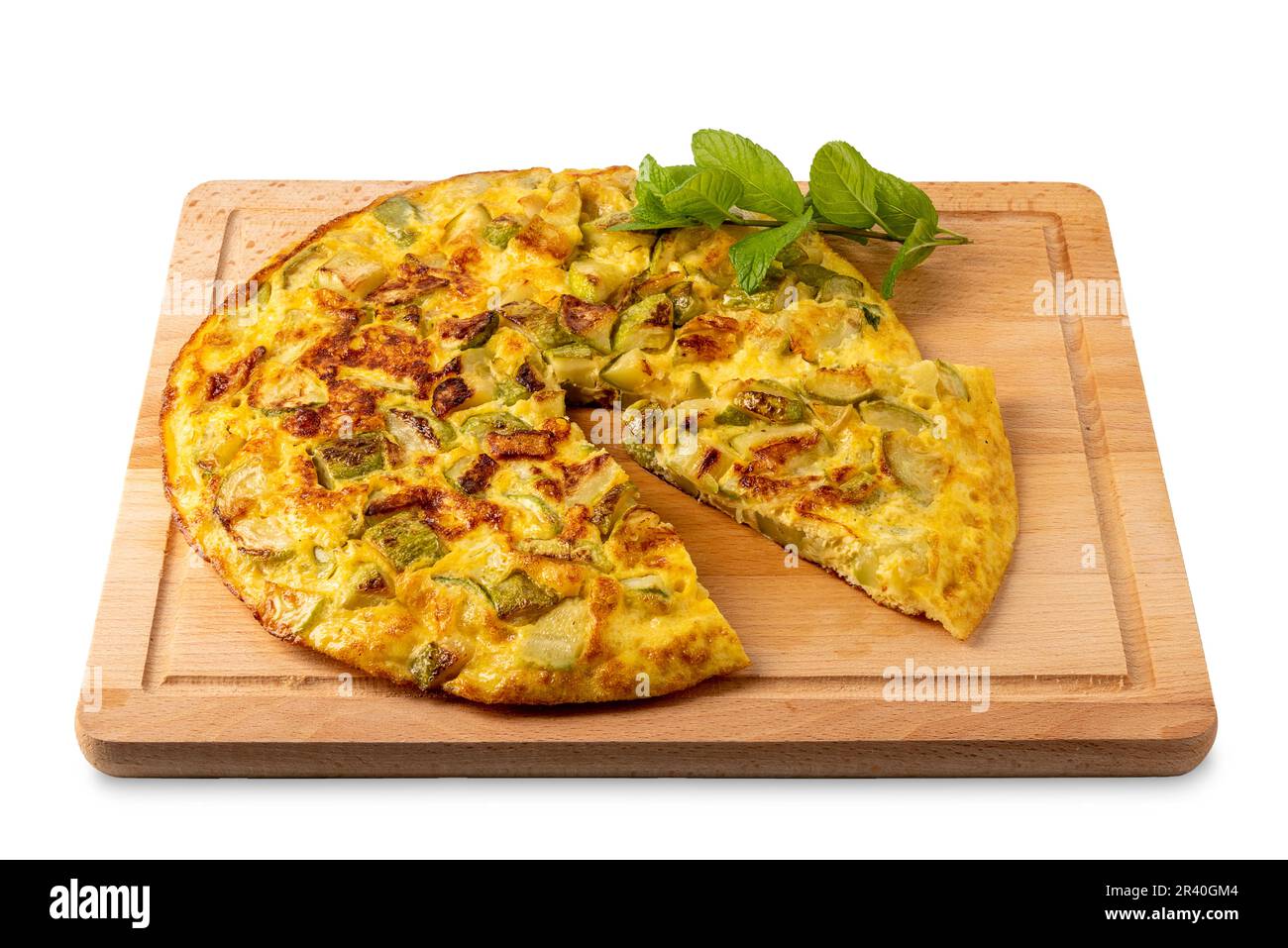 Omelette con zucchine con foglie e di menta, omelette intera con fettina tagliata su tagliere di legno isolato su bianco con percorso di taglio incluso Foto Stock
