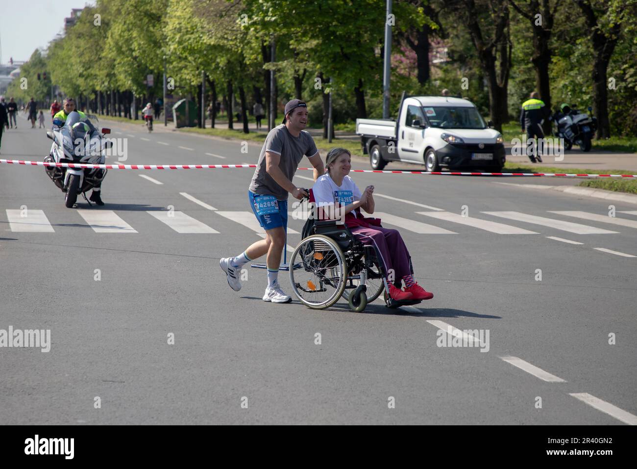 Belgrado, Serbia, 23 aprile 2023: Un uomo che spinge una sedia a rotelle partecipa a una gara di maratona Foto Stock