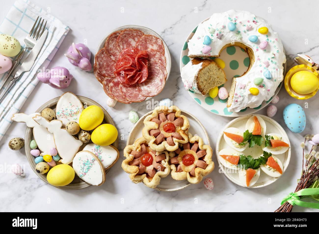 Cena festiva, brunch di Pasqua. Tavola di Pasqua scena con un assortimento di cottura, dessert, uova farcite e uova tinte su un marmo Foto Stock