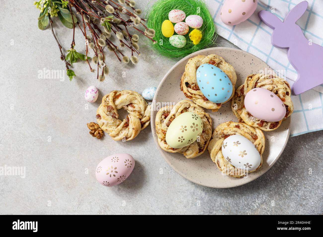 Composizione pasquale. Dolci anelli di pane pasquale italiano di pasta sfoglia e uova tinte su fondo di pietra. Vista dall'alto. Copia Foto Stock