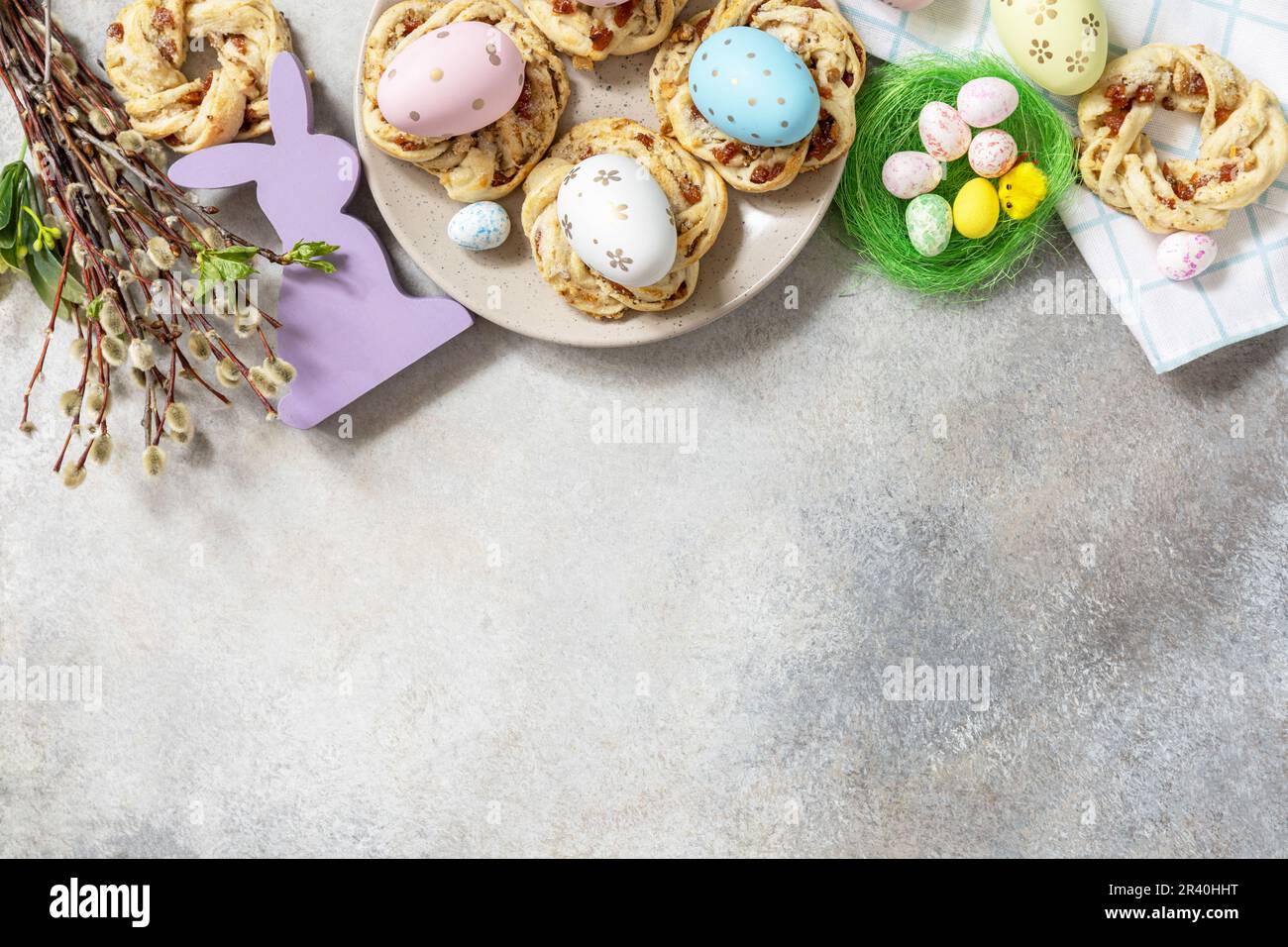 Composizione pasquale. Dolci anelli di pane pasquale italiano di pasta sfoglia e uova tinte su fondo di pietra. Vista dall'alto. Copia Foto Stock