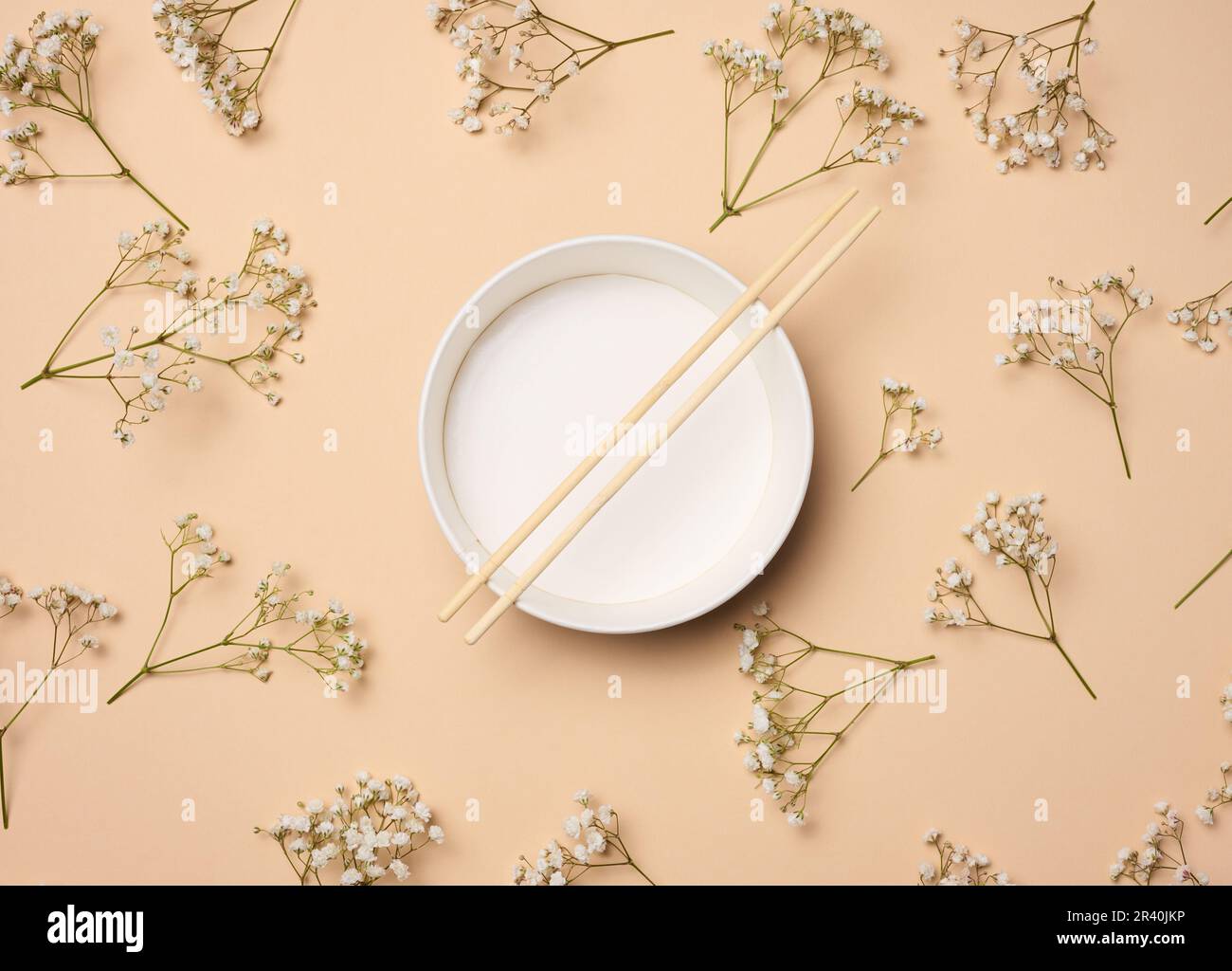 Aprire la ciotola vuota con e un paio di bastoni di legno su sfondo beige, vista dall'alto Foto Stock