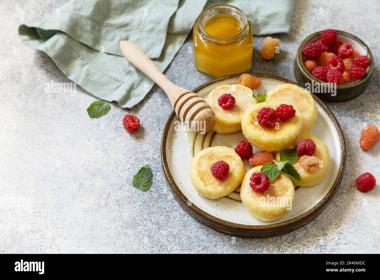 Casetta casereccia frittelle senza glutine (sciroppi, frittelle cagliate) con bacche su fondo di pietra. Frittelle di ricotta, morno Foto Stock