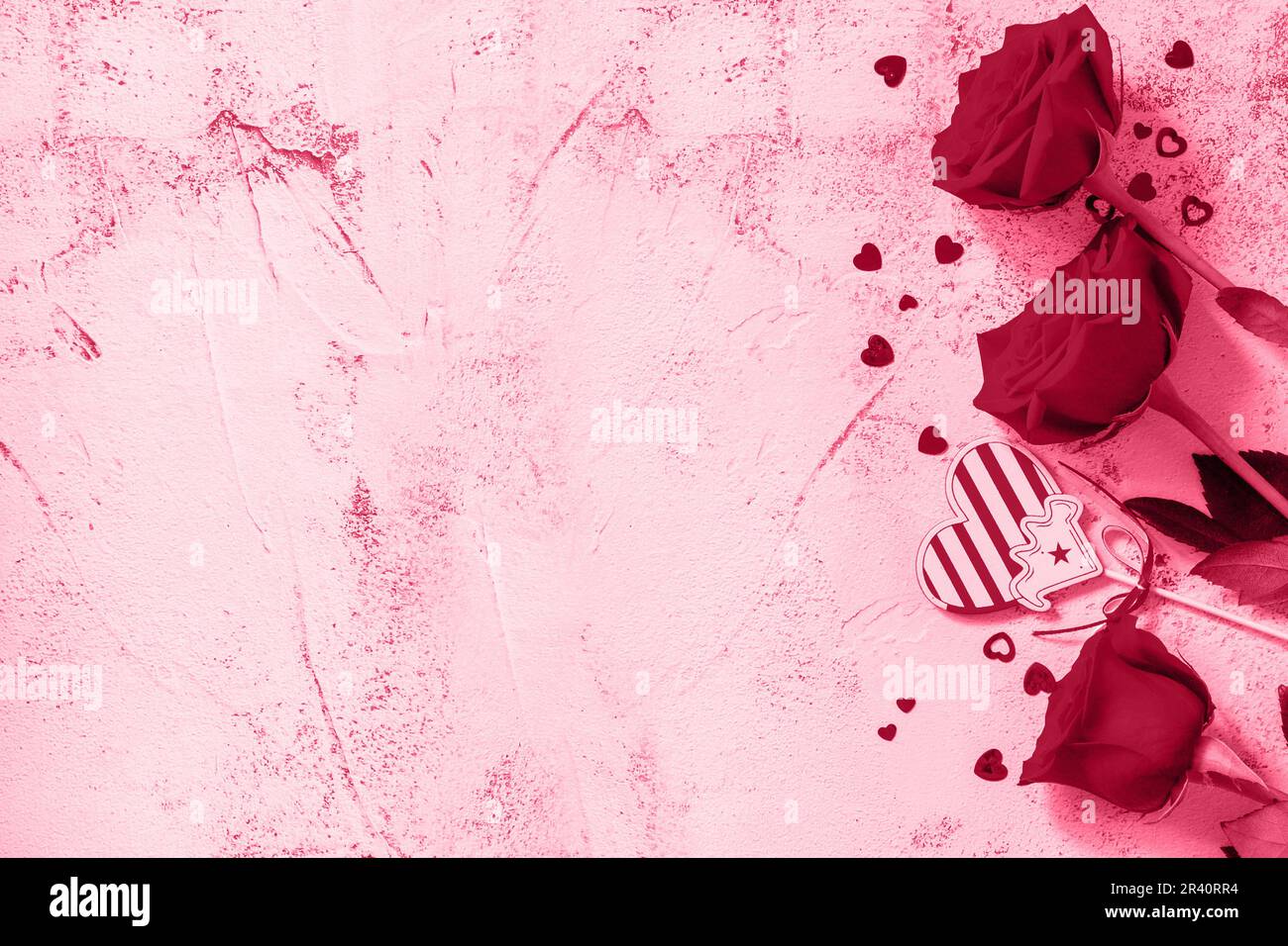 Concetto di San Valentino. Rose rosse e decorazioni a cuore. Disposizione piatta vista dall'alto. Colore trendy dell'anno 2023 - Viva Magenta. Foto Stock