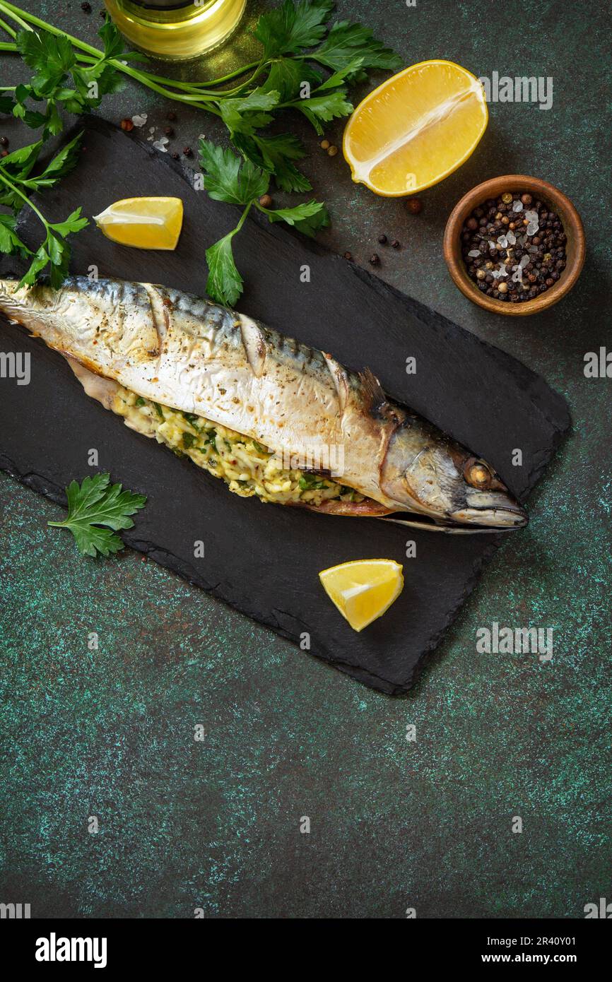 Sgombro cotto alla griglia ripieno di formaggio e uova su un ripiano in pietra. Cucina mediterranea. Disposizione piatta, vista dall'alto. Spazio di copia. Foto Stock