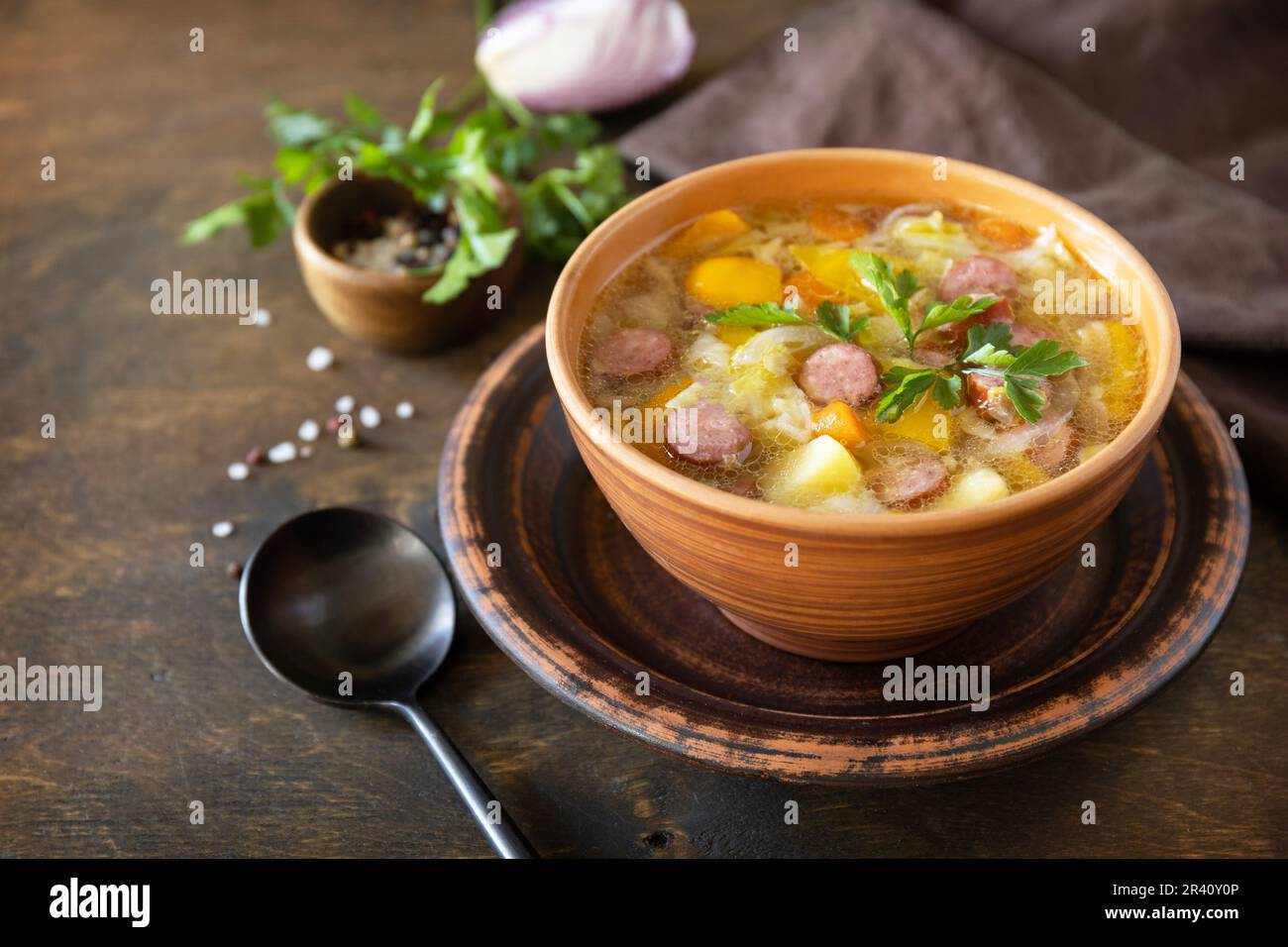 Cucina ceca: Zuppa di cavolo Zelnacka tradizionale con salsicce e verdure in una ciotola su un rustico tavolo di legno. Spazio di copia. Foto Stock