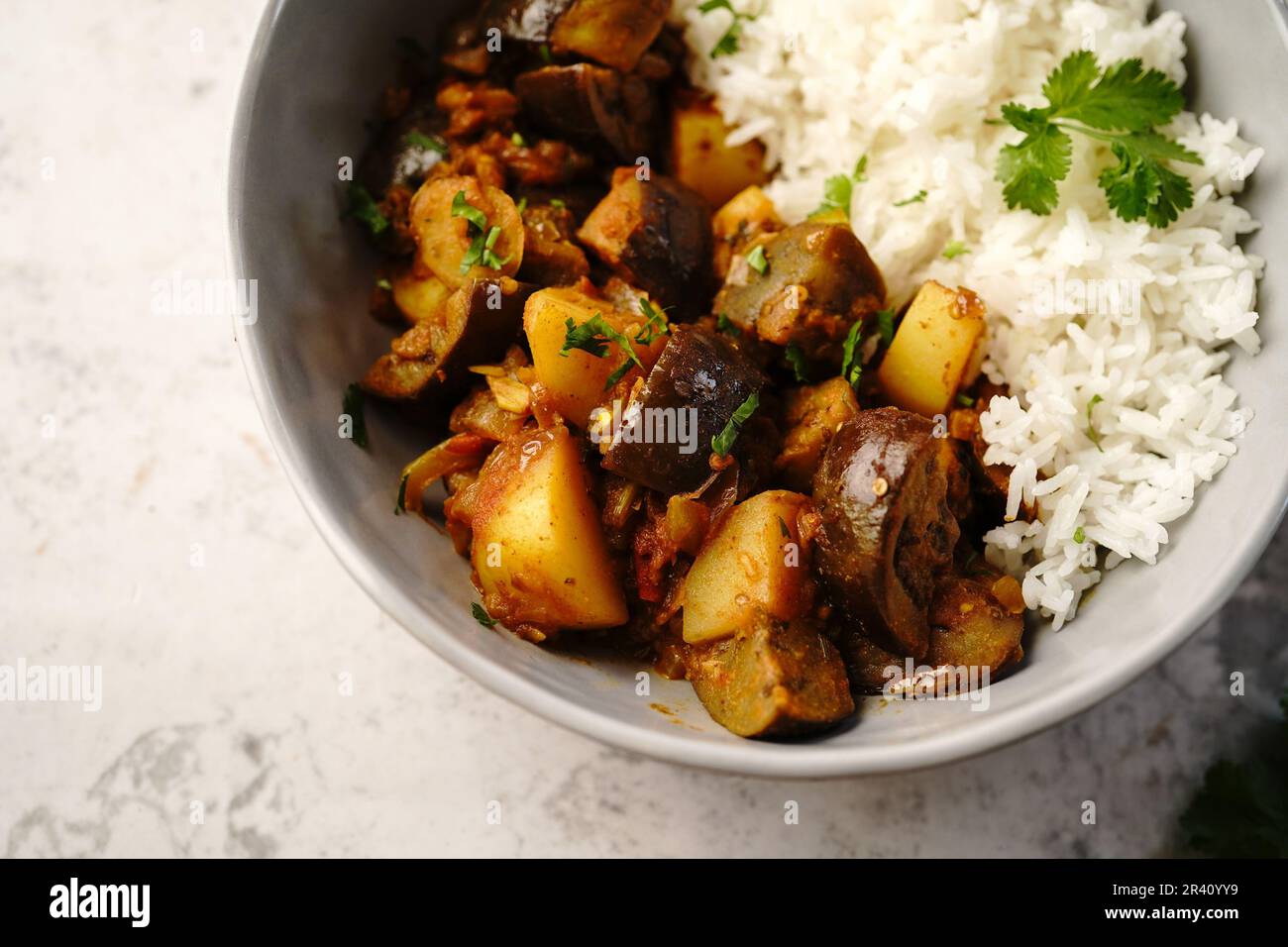 Alo Baingan o Eggplant patate masala servito con riso - piatti indiani vegetariani Foto Stock