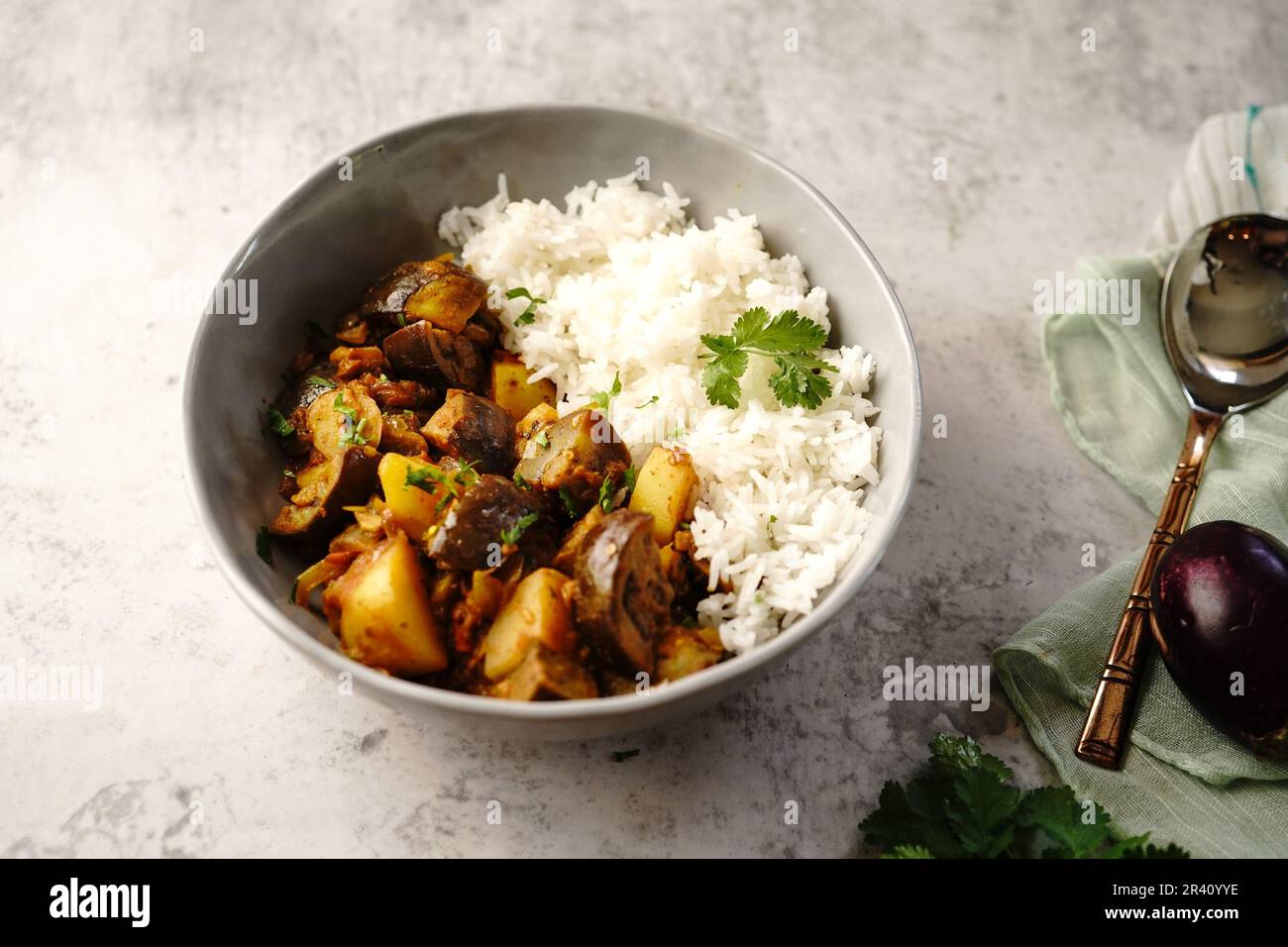 Alo Baingan o Eggplant patate masala servito con riso - piatti indiani vegetariani Foto Stock