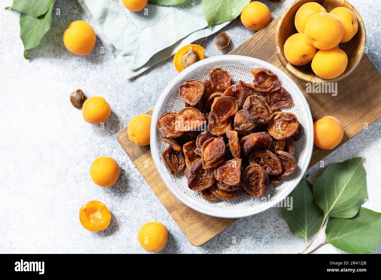 Frutta secca o candita. Albicocche secche e albicocche crude su fondo di pietra grigia. Vista dall'alto. Foto Stock