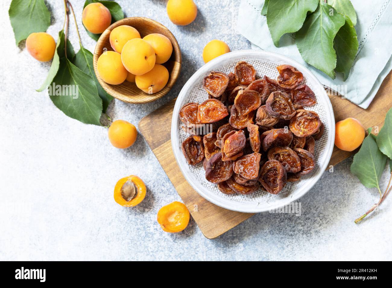 Frutta secca o candita. Albicocche secche e albicocche crude su fondo di pietra grigia. Vista dall'alto. Spazio di copia. Foto Stock