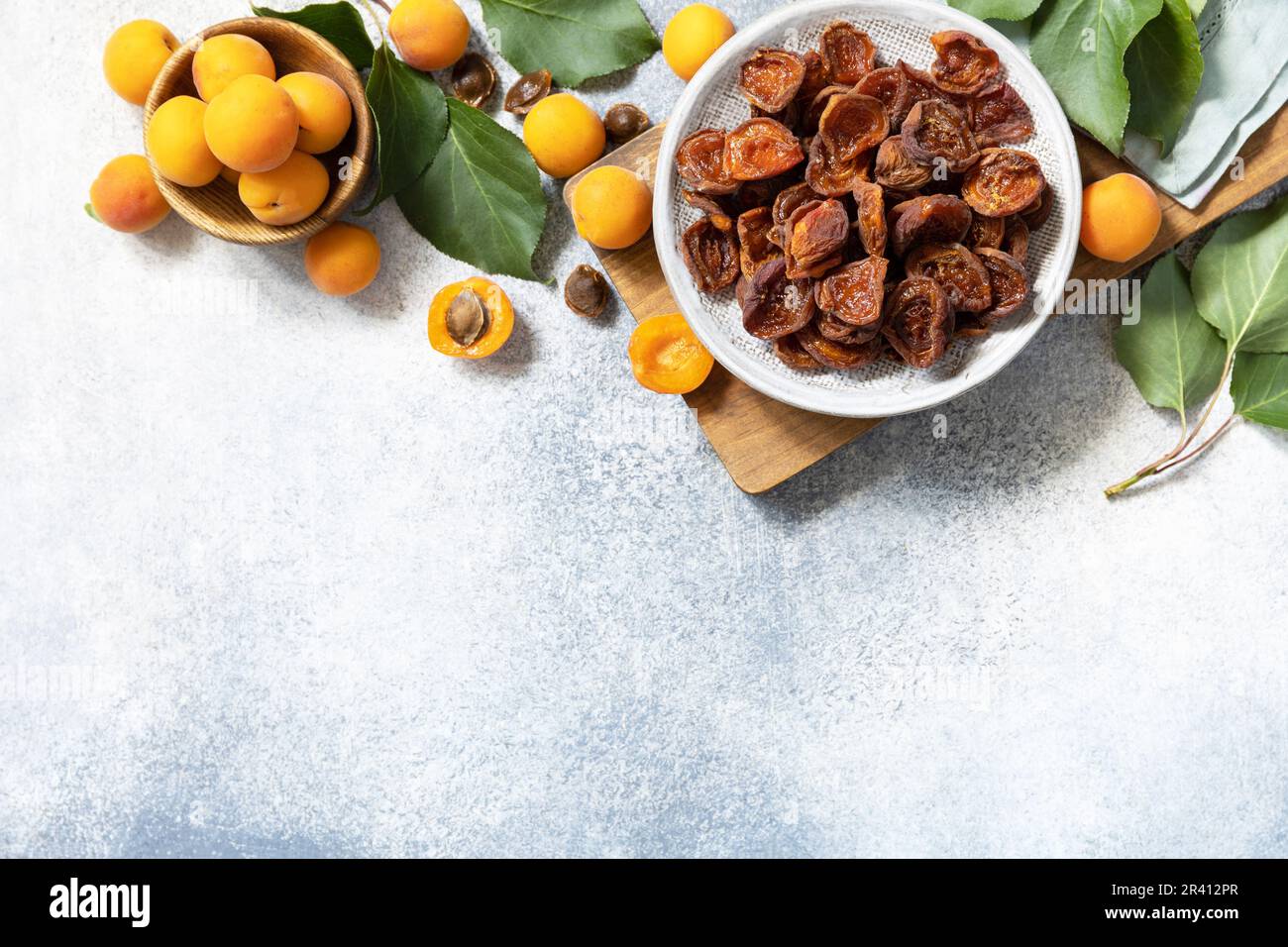 Frutta secca. Albicocche secche e albicocche crude su fondo di pietra grigia. Vista dall'alto. Spazio di copia. Foto Stock