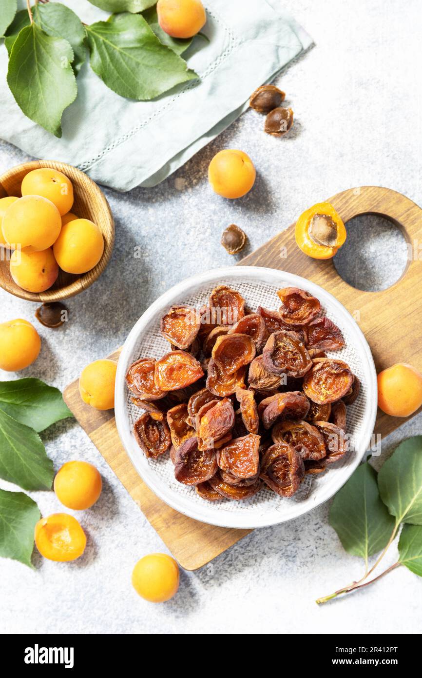 Frutta secca. Albicocche secche e albicocche crude su fondo di pietra grigia. Vista dall'alto. Foto Stock