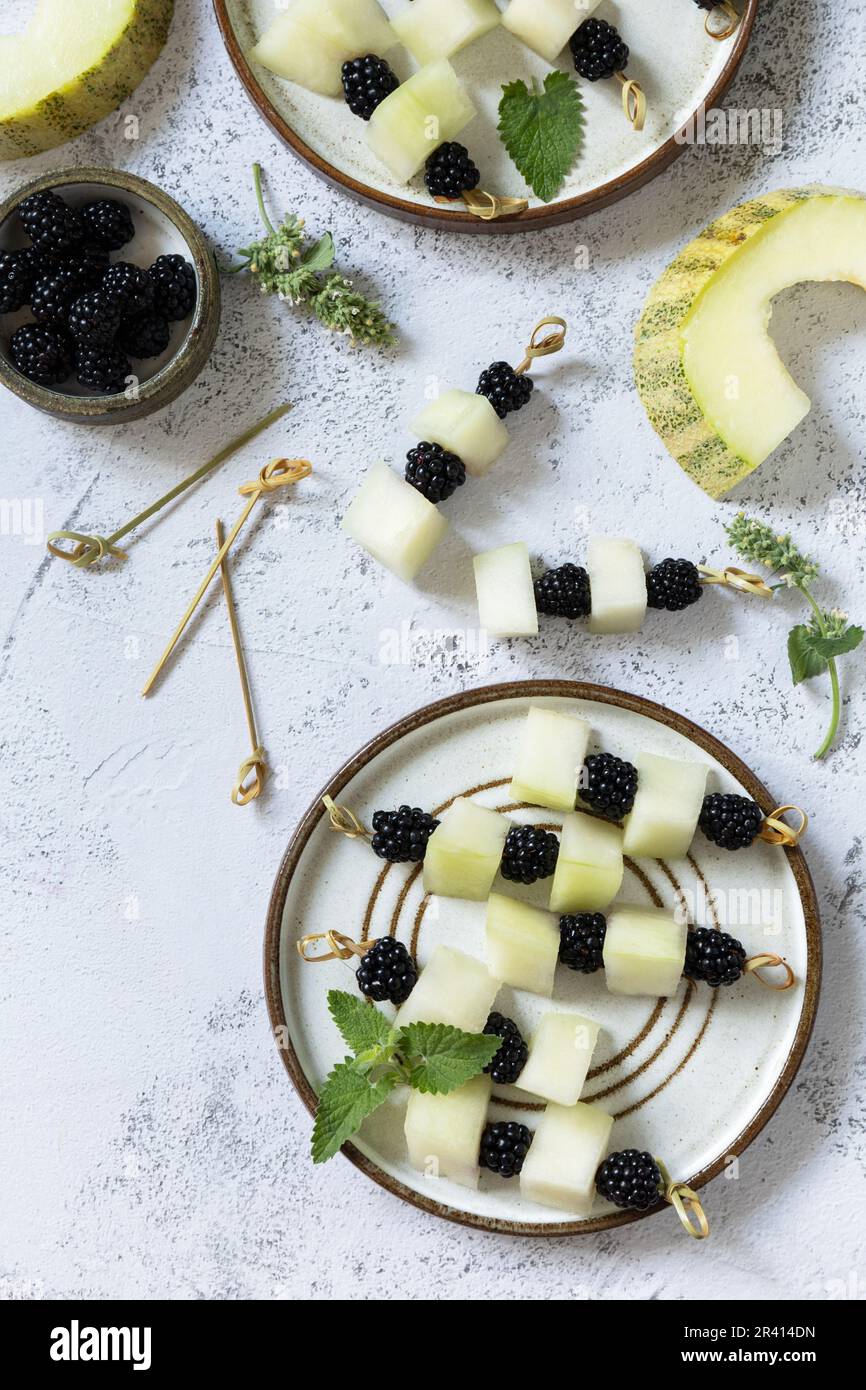 Festivo spuntino estivo di frutta e canape. Cibo vegano. Tartine con melone e more su un piano di pietra. Visualizza da Foto Stock