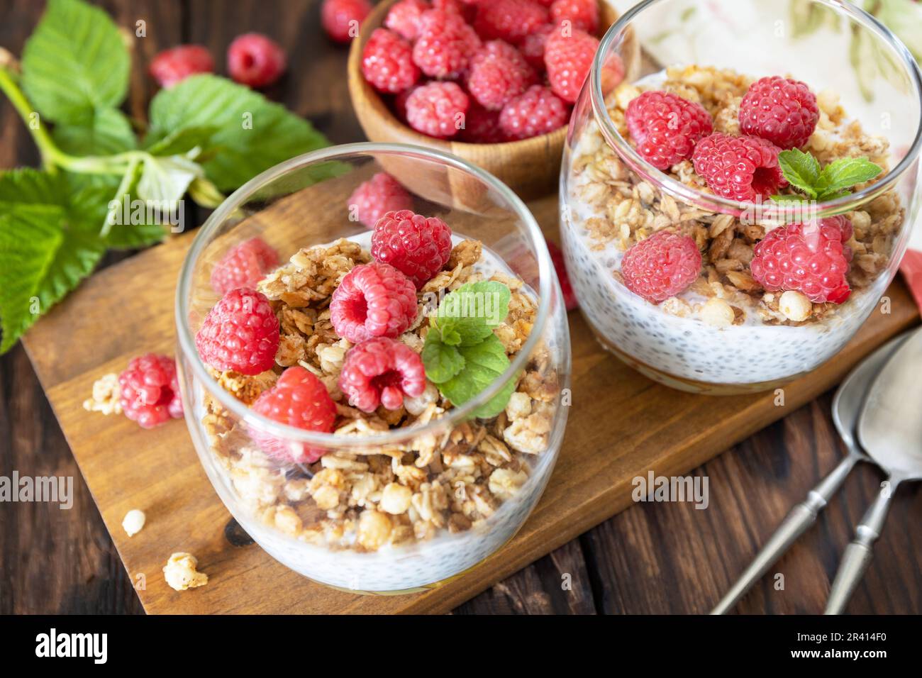 Concetto di menu della colazione sano. Colazione fatta in casa in granola. Bicchiere di parfait di muesli, lampone di frutti di bosco, yogurt con ch Foto Stock