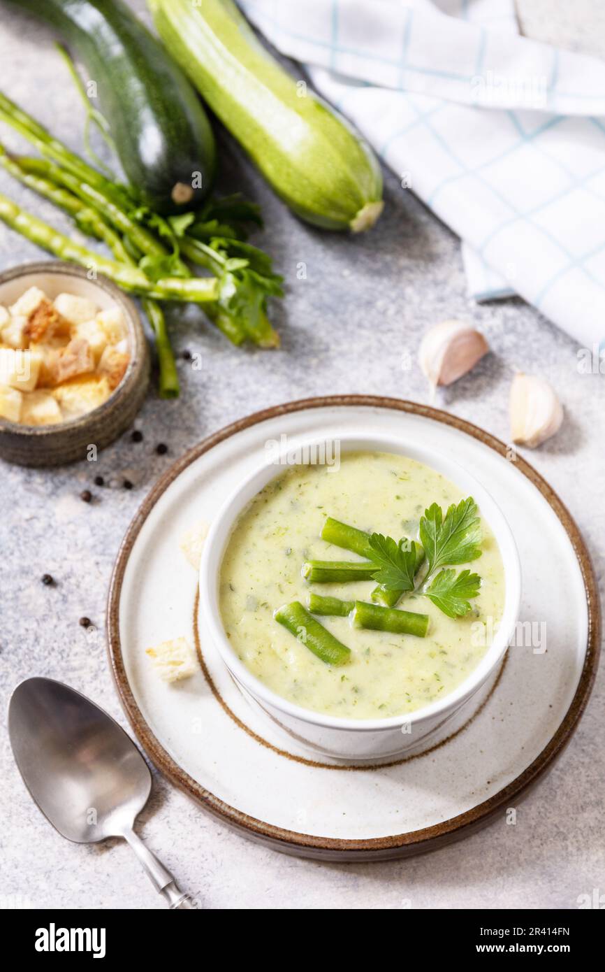 Cibo sano. Purea di verdure verdi per zuppa vegana. Ciotola di fagiolo verde e zuccini crema su un tavolo di pietra. Foto Stock