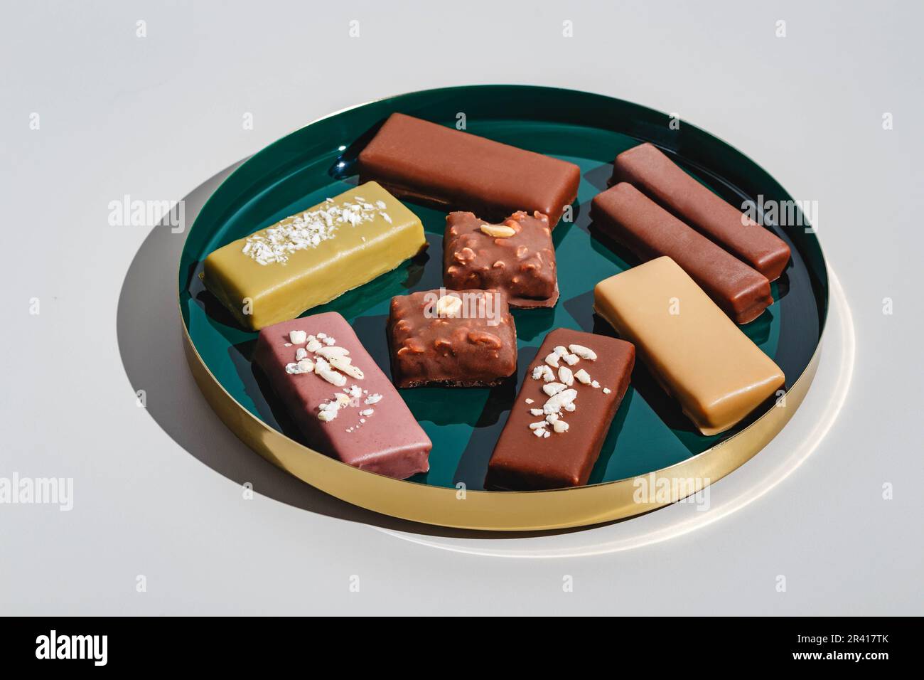 Set di barrette da dessert con diversi tipi di cioccolato su sfondo chiaro. Luce dura, ombra profonda Foto Stock