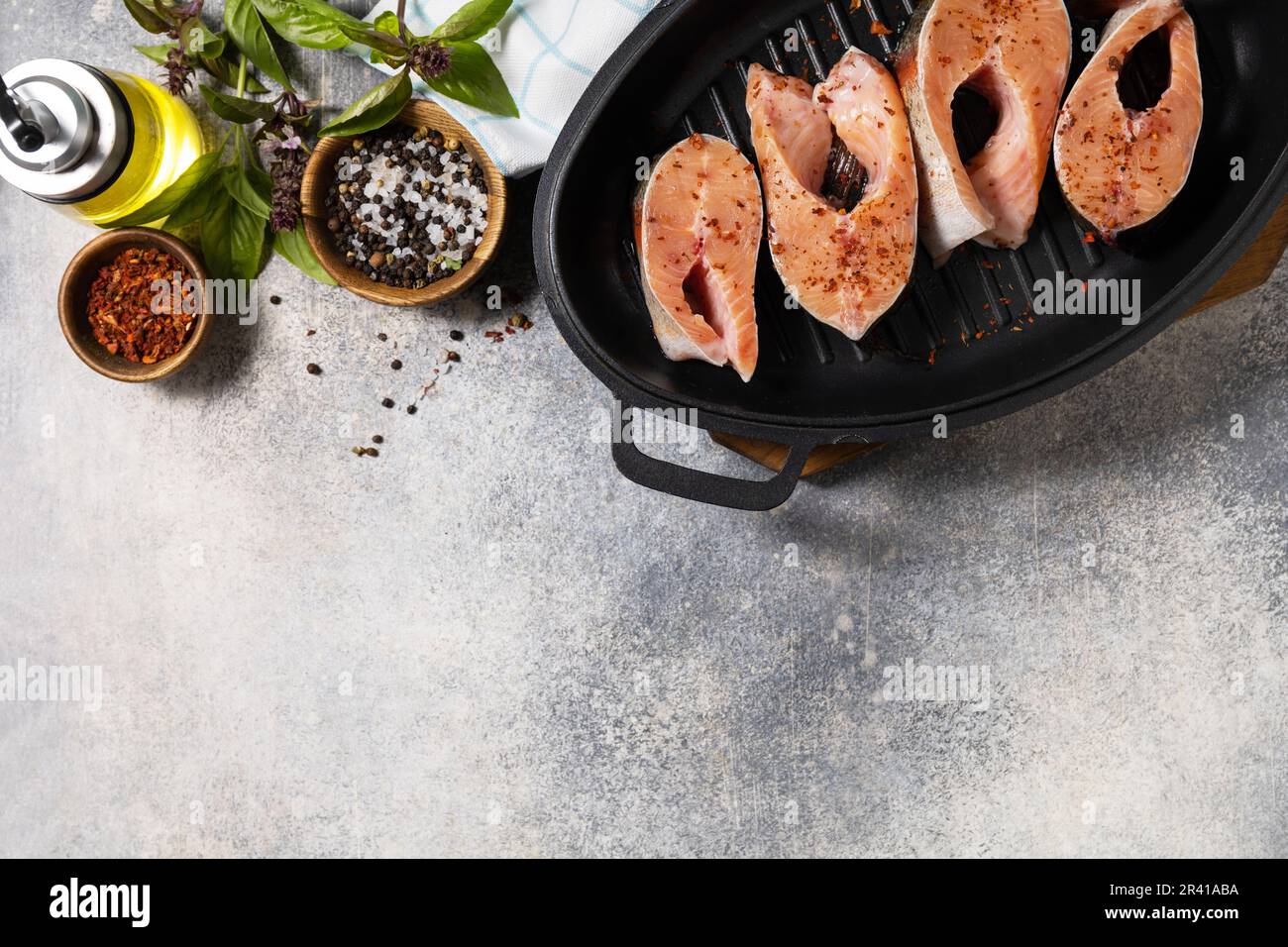 Pezzi di filetto di salmone fresco con spezie su una padella alla griglia. Pesce, sfondo culinario. Vista dall'alto. Spazio di copia. Foto Stock