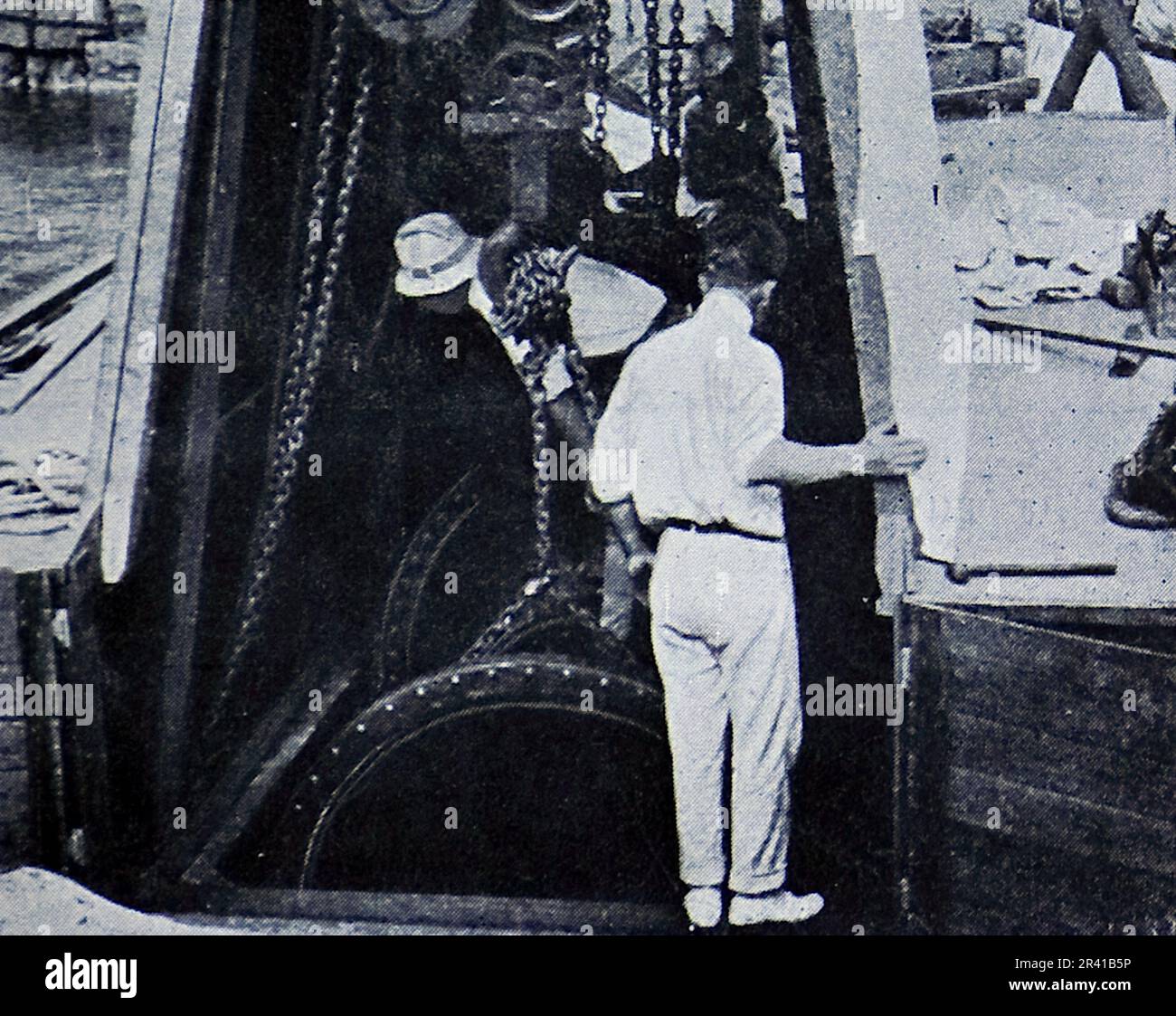 La spedizione sottomarina di Williamson del 1914 è stata la prima a rivelare alcuni dei tesori sotto la superficie dell'oceano. Grazie in gran parte a tecniche fotografiche innovative la biologia marina intorno alle Bahamas è entrata in vita. Questa foto mostra: Abbassando la camera operativa (sottomarina) nel mare attraverso il pozzo della chiatta. Foto Stock