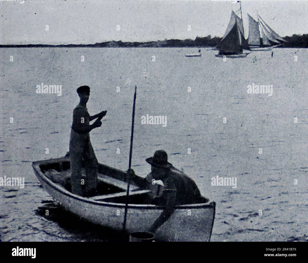 La spedizione sottomarina di Williamson del 1914 è stata la prima a rivelare alcuni dei tesori sotto la superficie dell'oceano. Grazie in gran parte a tecniche fotografiche innovative la biologia marina intorno alle Bahamas è entrata in vita. Questa foto mostra: Pesca della spugna: Il nativo sulla destra sta guardando attraverso un secchio con un fondo di vetro. Foto Stock