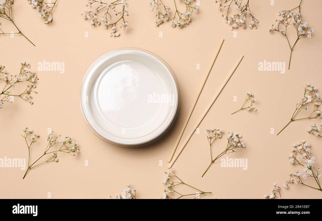 Aprire la ciotola vuota con e un paio di bastoni di legno su sfondo beige, vista dall'alto Foto Stock
