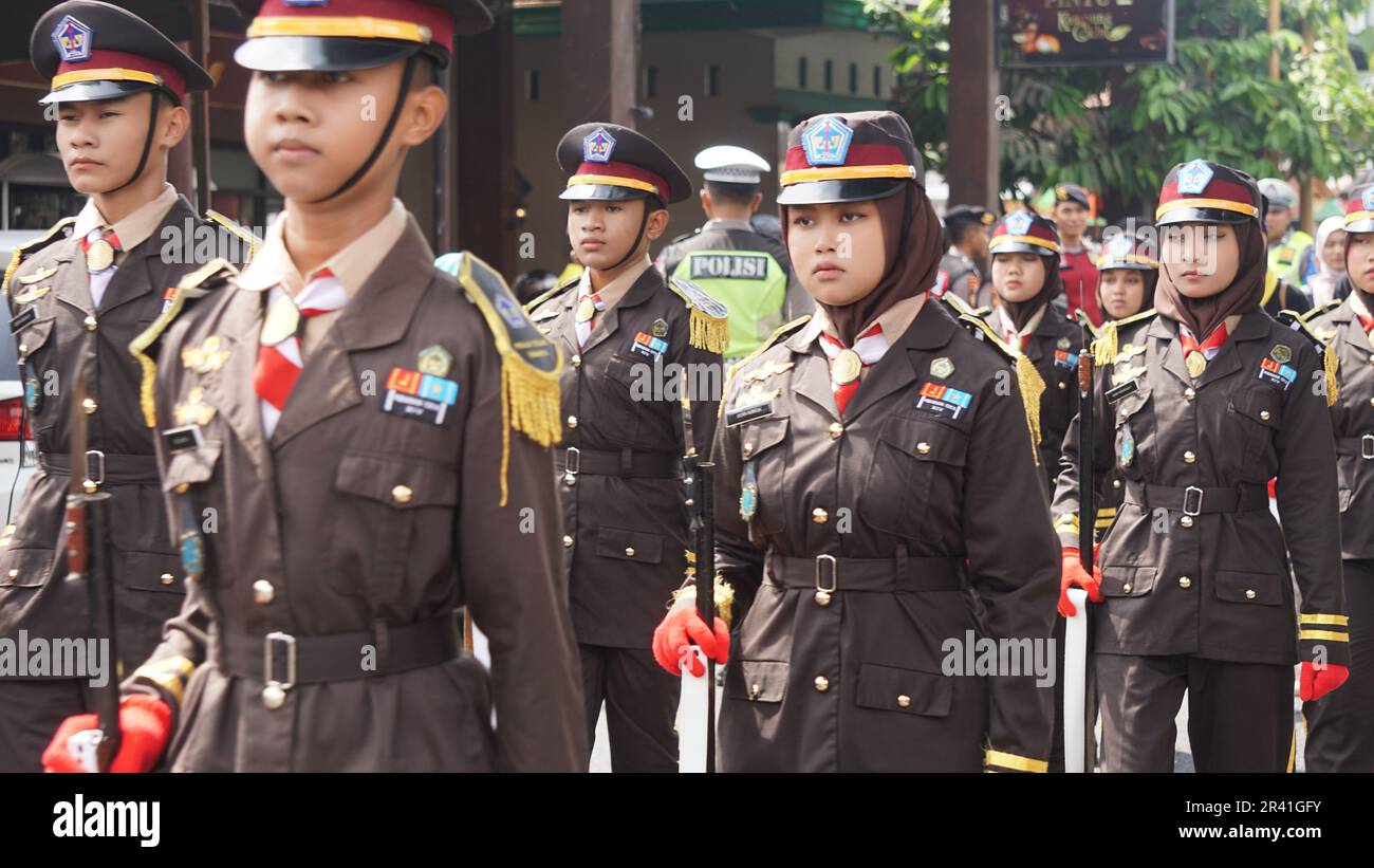 Studenti indonesiani di scuola superiore con uniformi in marcia Foto Stock
