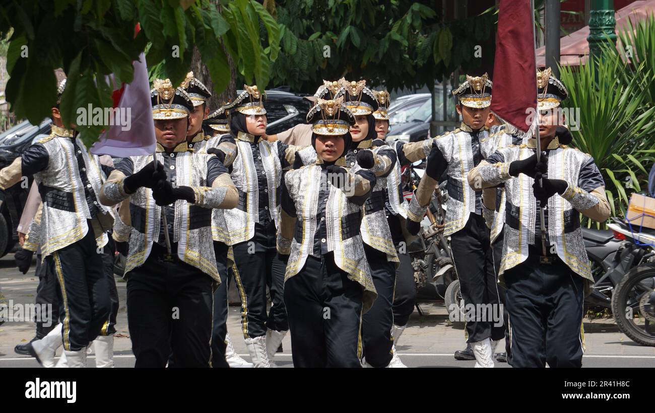 Studenti indonesiani di scuola superiore con uniformi in marcia Foto Stock