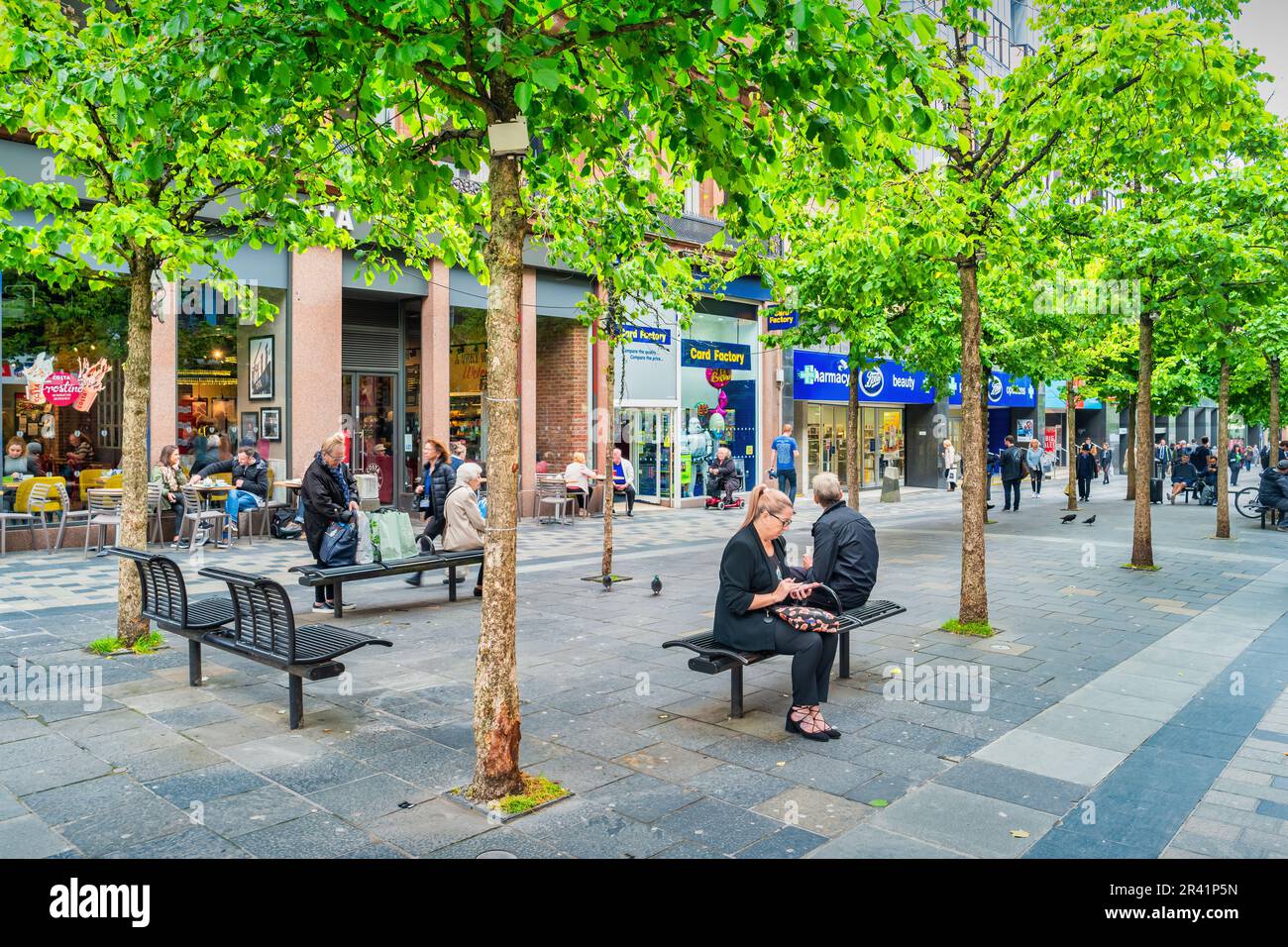 La gente si rilassa nel quartiere dello shopping di Sauchiehall Street nel centro di Glasgow, Scozia, Regno Unito Foto Stock