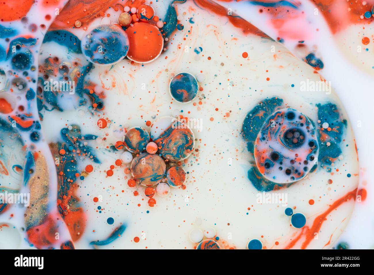 Fondo orizzontale astratto con latte bianco e vernice blu acrilico arancione e oro versato con olio creando effetto marmorizzato Foto Stock