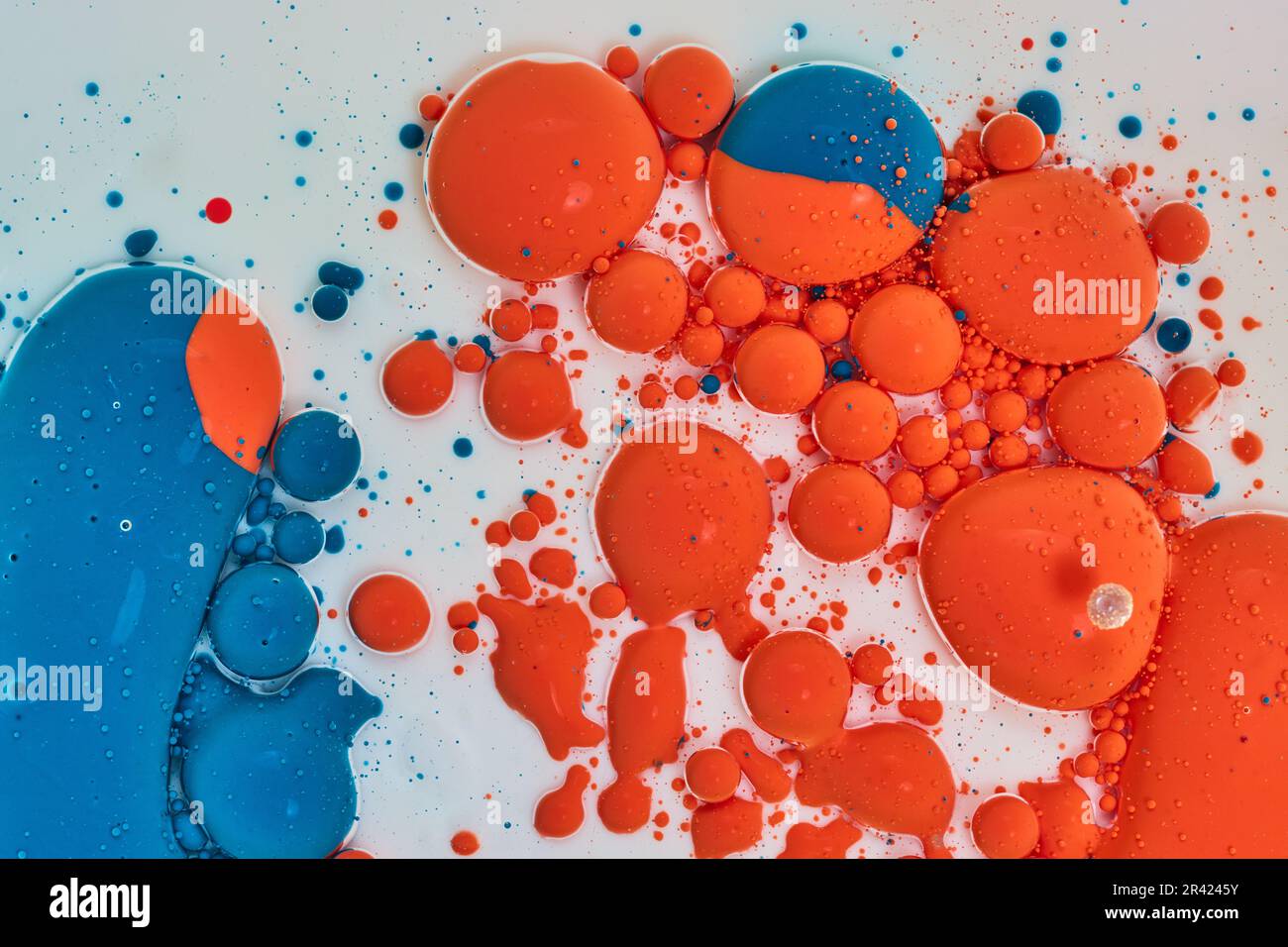 Sfere e bolle arancioni e blu che ballano su sfondo bianco Foto Stock