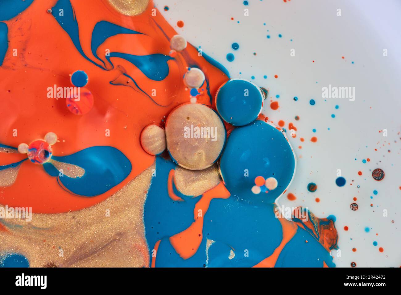 Pittura astratta verticale con fondo bianco e macchie di oro blu e vernice acrilica arancione con bolle d'olio in un cluster Foto Stock