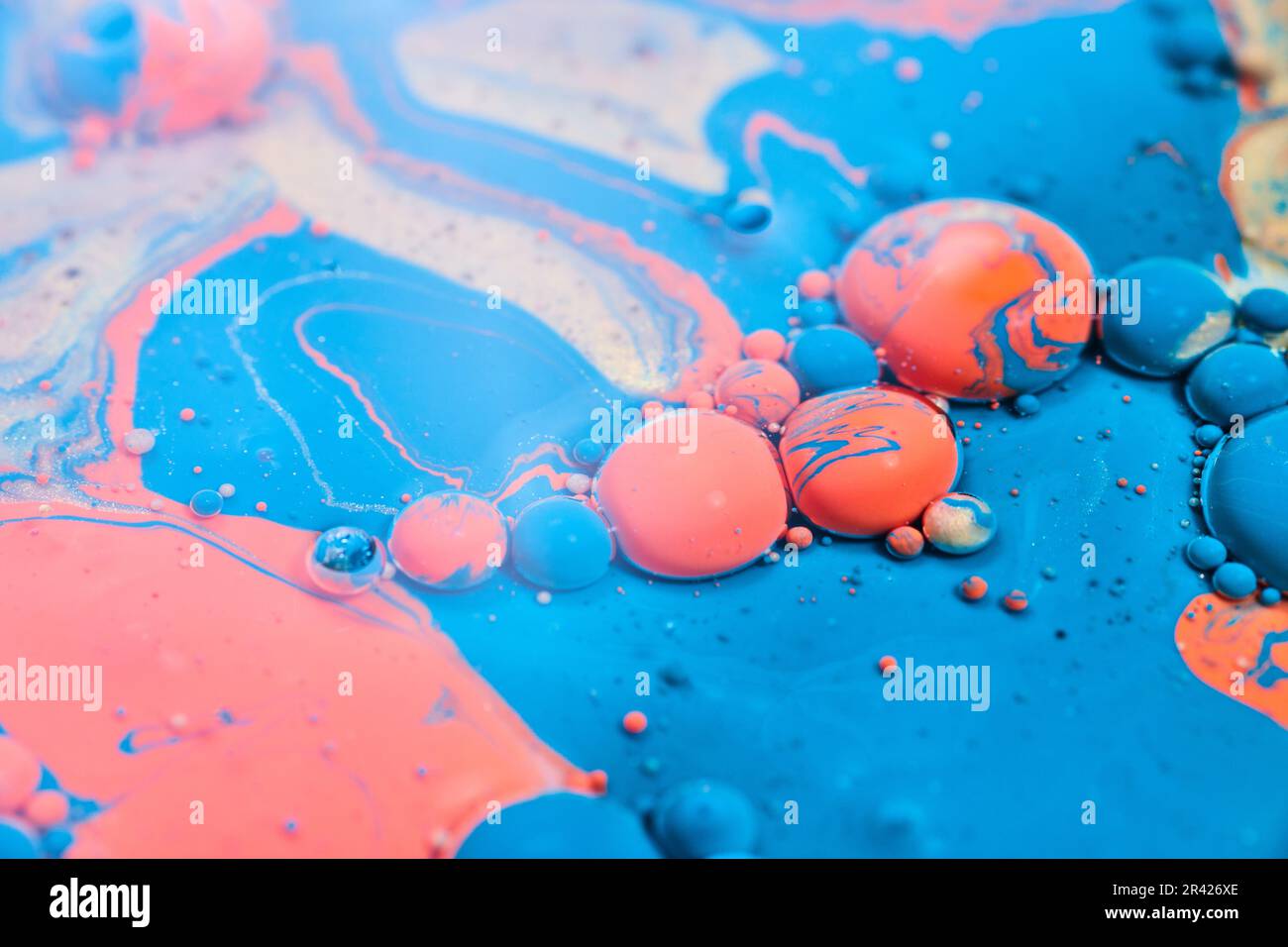 Lucido acrilico astratto versare con olio e un blu palline arancio e swirls dorati in fondo risorsa Foto Stock