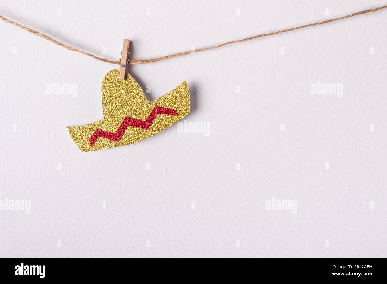 Carta fai da te Garland fatto di lucido cappello sombrero contro parete bianca. Decorazione festiva minima. Cinco de mayo concetto Foto Stock