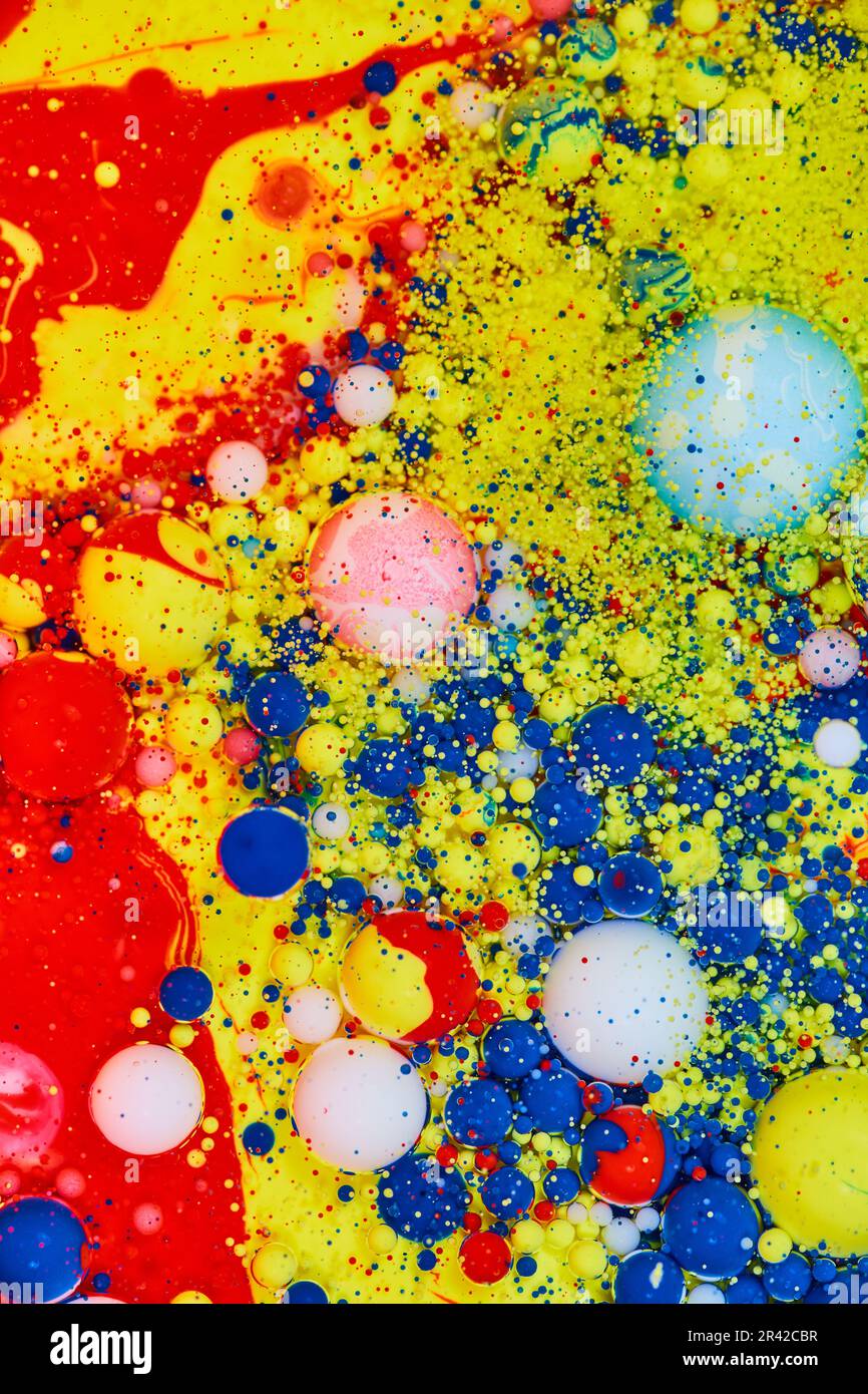 Verticale di pittura acrilica rossa e gialla con bolle e macchie di blu e bianco Foto Stock
