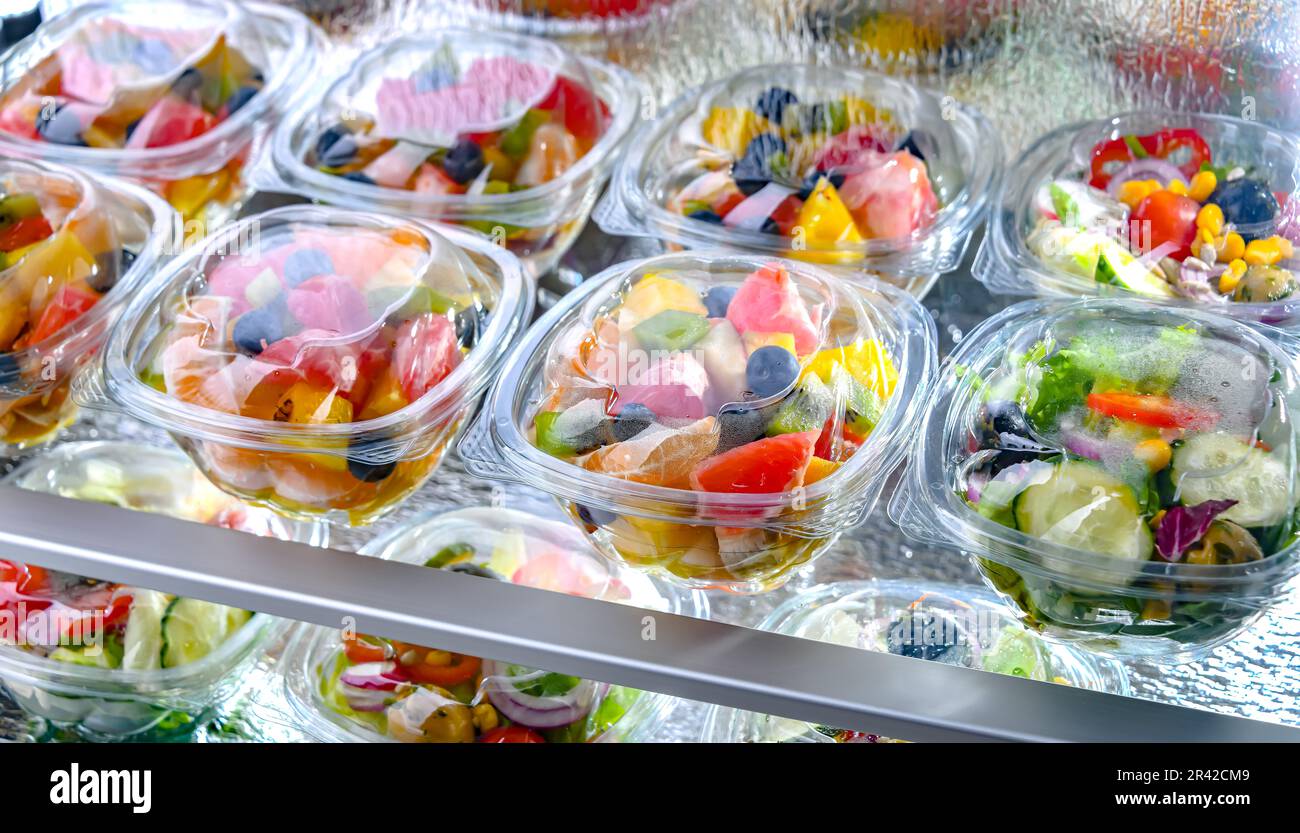Scatole di plastica con insalate di frutta e verdura preconfezionate Foto Stock