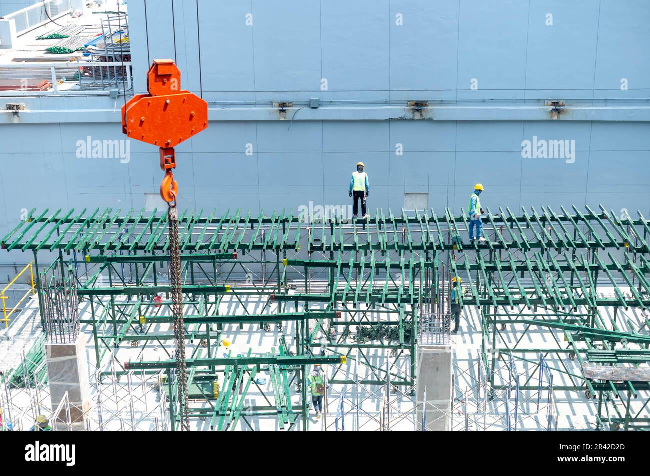 Vista del cantiere e delle gru rosse per la costruzione di una moderna zona residenziale, concetto di costruzione per la città in via di sviluppo. Foto Stock