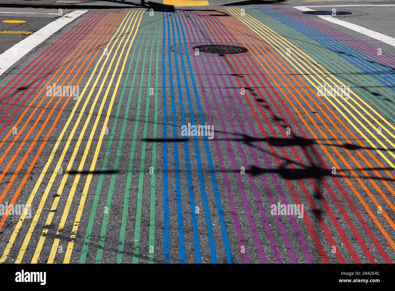 Rainbow Crosswalk in una giornata di sole con intricate ombre nel Castro District, San Francisco, California. Sfondo vuoto Foto Stock