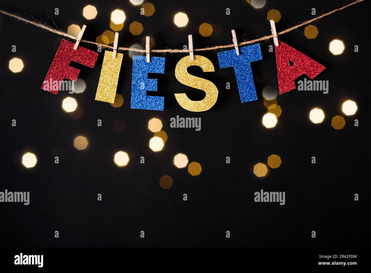 Parola Fiesta fatta di carta lucida e spille su sfondo nero e luci bokeh. Cinco de mayo concetto Foto Stock