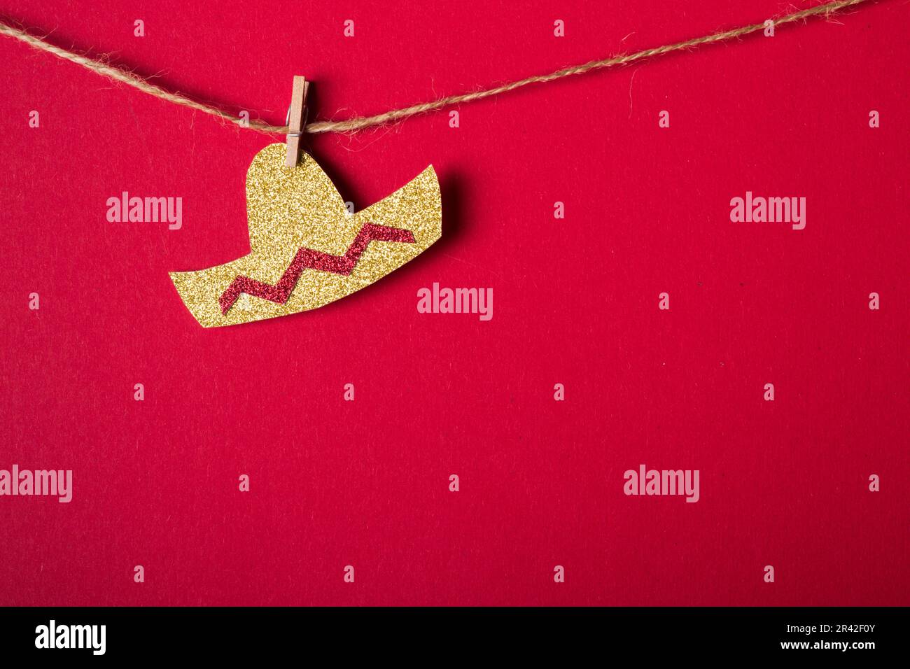 Cappello Sombrero in carta lucida su sfondo rosso. Decorazione festiva minima. Cinco de mayo concetto Foto Stock