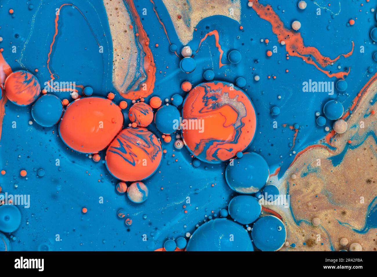 Mare astratto di vernice blu acrilico con sfere d'uovo pasquale di arancio e blu in pallini d'oro in fondo orizzontale risorsa Foto Stock