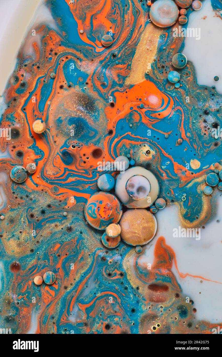 Pittura acrilica a goccia d'olio astratta con vorticoso oro blu arancio e bolle bianche e sfere in marmo come risorsa di sfondo Foto Stock