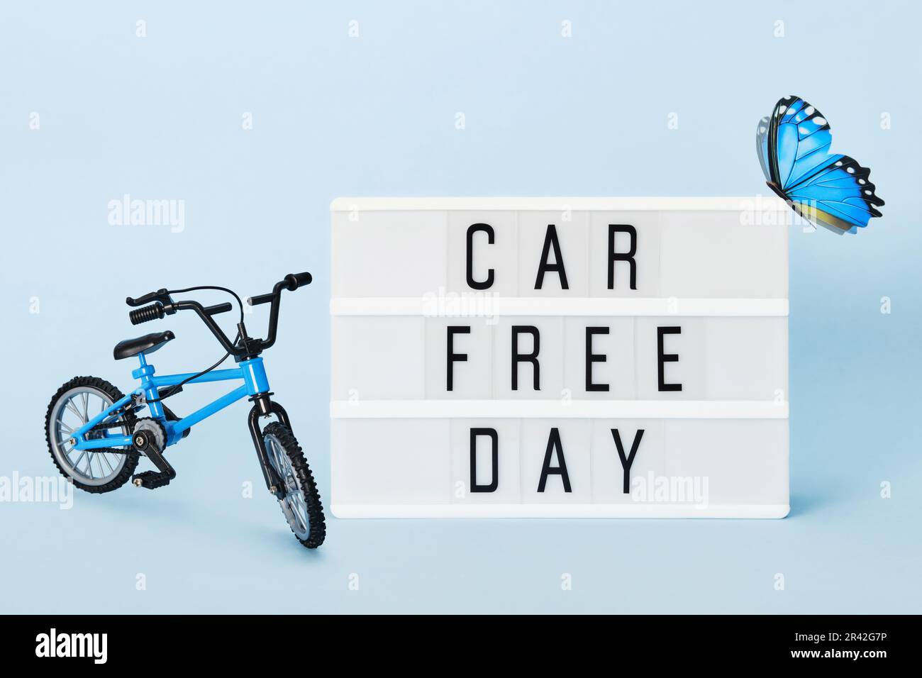 Concetto di giorno libero dell'automobile. Light box con auto testo libero giorno bicicletta e farfalla. Giornata mondiale della bicicletta Foto Stock