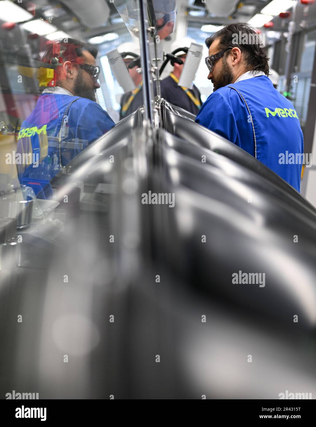 Darmstadt, Germania. 23rd maggio, 2023. Paul Mehlmann, scienziato nel settore dell'elettronica del gruppo farmaceutico e tecnologico Merck KGaA, con sede a Darmstadt, lavora in un cosiddetto 'cassetto portaoggetti' con molecole utilizzate per la produzione di semiconduttori. Questi materiali sono estremamente sensibili e si decompongono al contatto con ossigeno e umidità. Credit: Arne Dedert/dpa/Alamy Live News Foto Stock