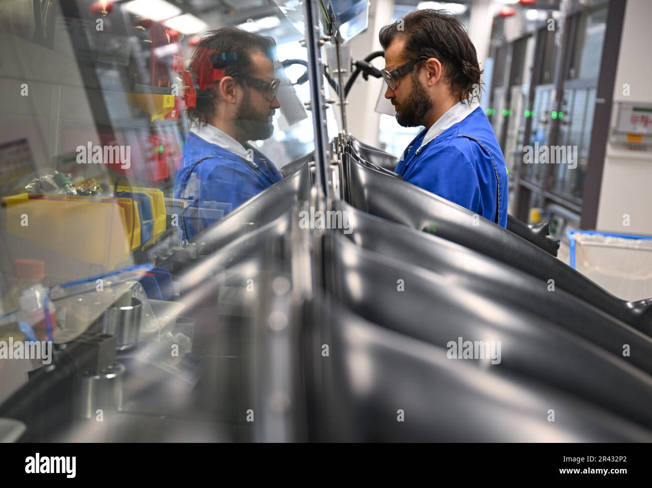 Darmstadt, Germania. 23rd maggio, 2023. Paul Mehlmann, scienziato nel settore dell'elettronica del gruppo farmaceutico e tecnologico Merck KGaA, con sede a Darmstadt, lavora in un cosiddetto 'cassetto portaoggetti' con molecole utilizzate per la produzione di semiconduttori. Questi materiali sono estremamente sensibili e si decompongono al contatto con ossigeno e umidità. Credit: Arne Dedert/dpa/Alamy Live News Foto Stock