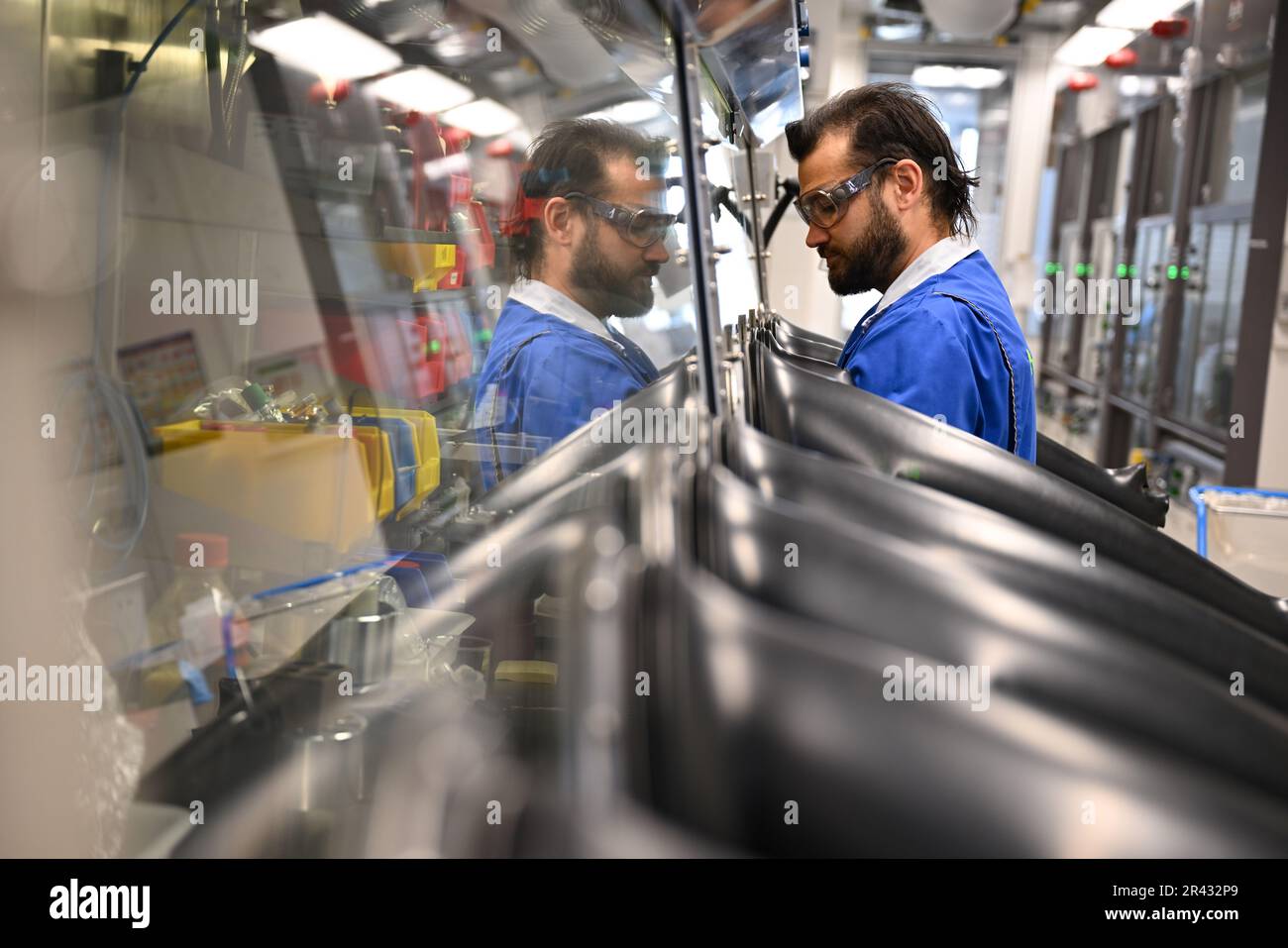 Darmstadt, Germania. 23rd maggio, 2023. Paul Mehlmann, scienziato nel settore dell'elettronica del gruppo farmaceutico e tecnologico Merck KGaA, con sede a Darmstadt, lavora in un cosiddetto 'cassetto portaoggetti' con molecole utilizzate per la produzione di semiconduttori. Questi materiali sono estremamente sensibili e si decompongono al contatto con ossigeno e umidità. Credit: Arne Dedert/dpa/Alamy Live News Foto Stock