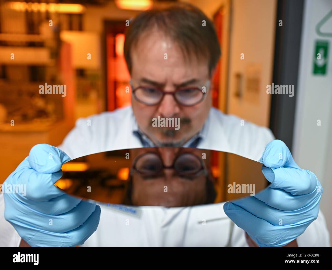 Darmstadt, Germania. 23rd maggio, 2023. Jens Pradella, scienziato nel settore dell'elettronica del gruppo farmaceutico e tecnologico Merck KGaA, con sede a Darmstadt, detiene un wafer non rivestito in un laboratorio. Credit: Arne Dedert/dpa/Alamy Live News Foto Stock