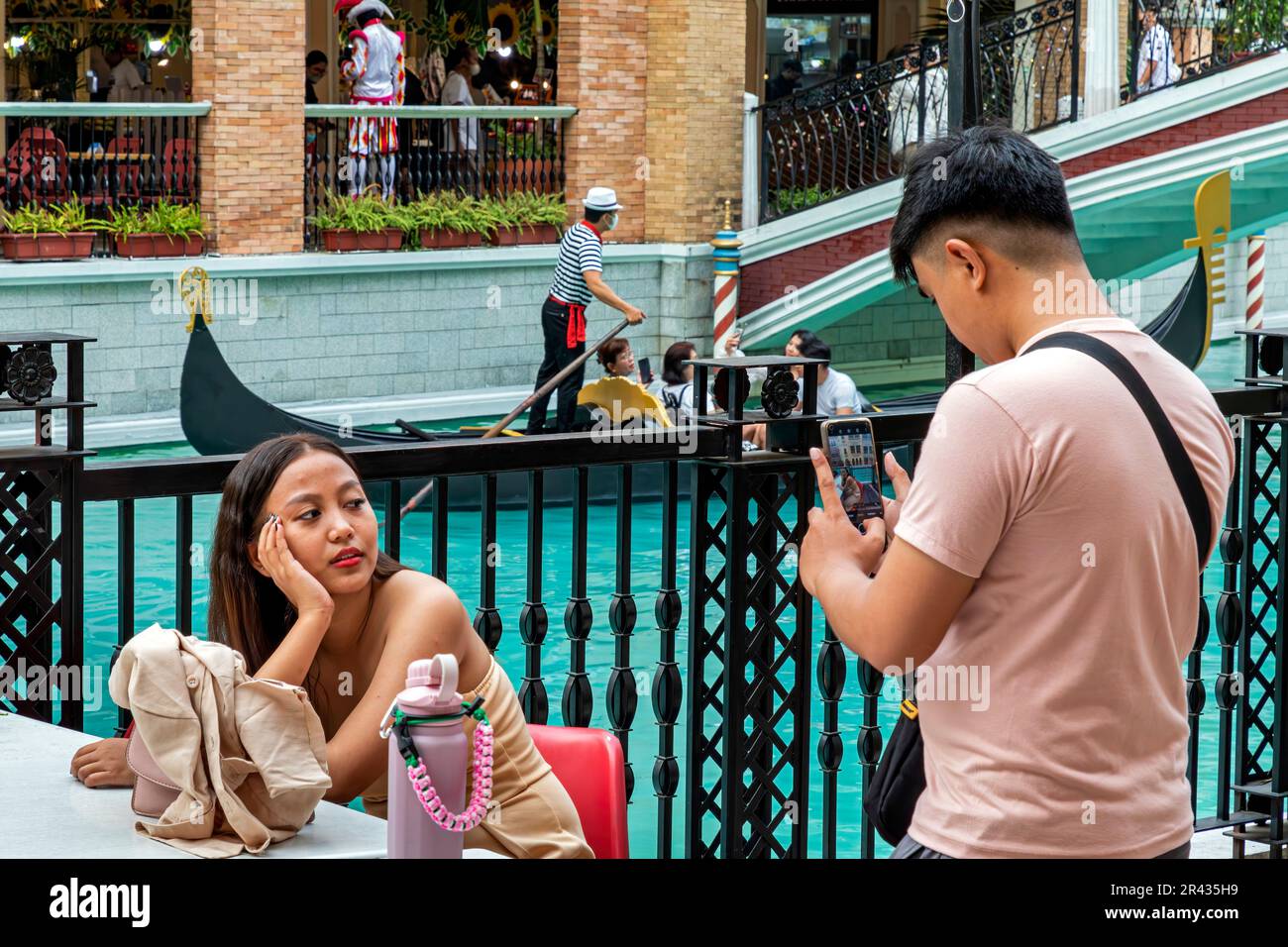 Coppia asiatica che scatta foto con le gondole al Venice Grand Canal Mall, Taguig City, Manila, Filippine Foto Stock