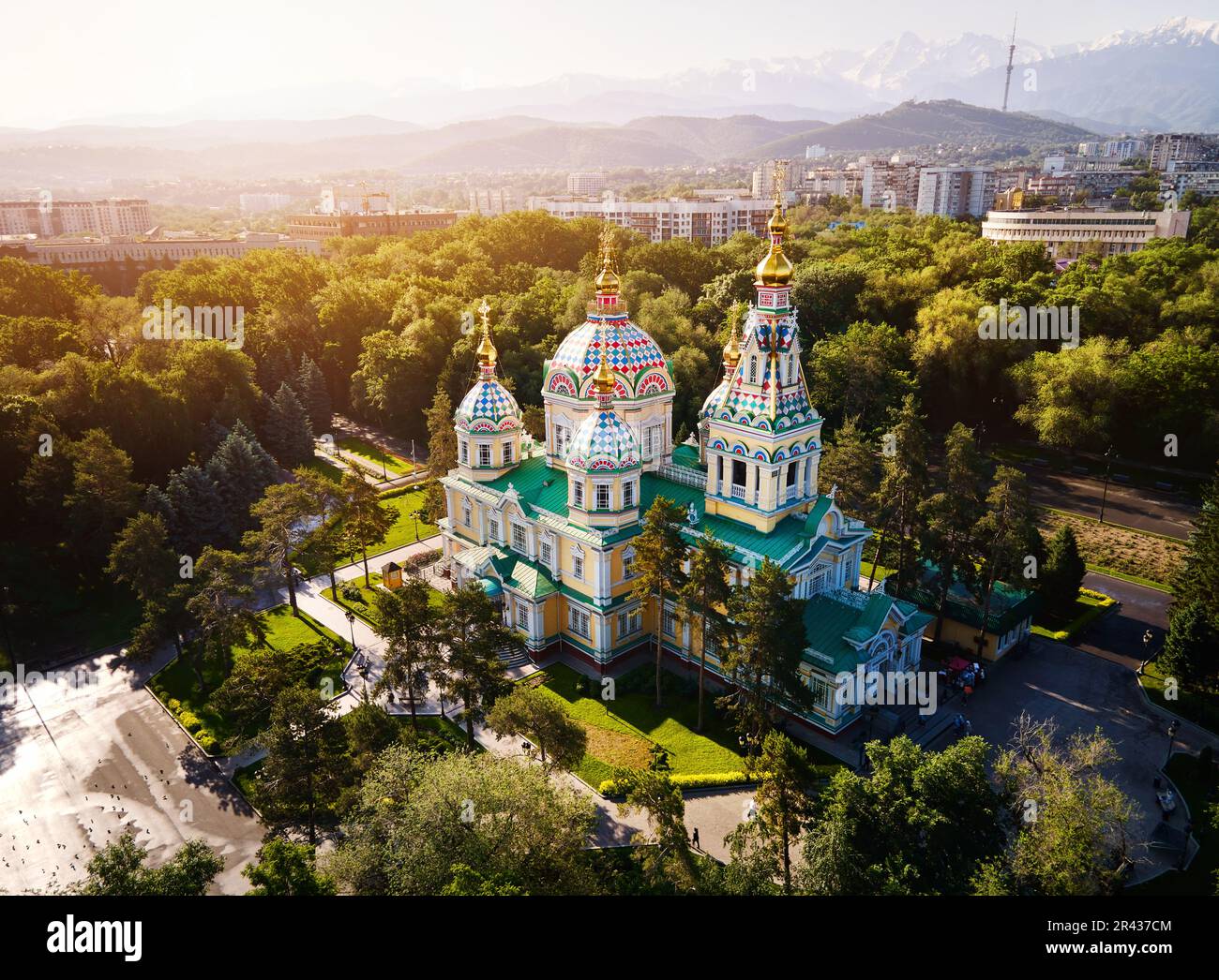 Panorama aereo del drone della Cattedrale dell'Ascensione Chiesa ortodossa russa e montagne di neve sullo sfondo del Parco Panfilov alla luce dell'alba ad al Foto Stock