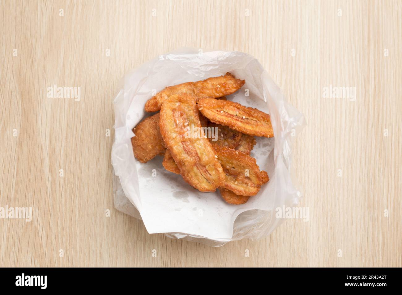 Kluay Khak o Kluay Tod (Banana immersa) in farina fritta e confezionata in sacchetti di plastica, un popolare spuntino tailandese. Foto Stock