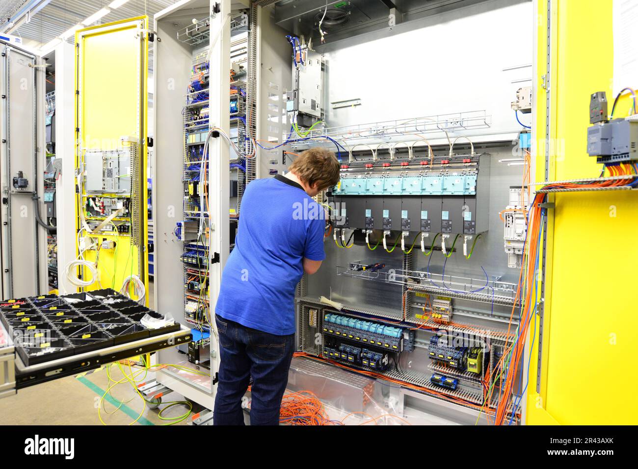 Operatore macchina assembla in una fabbrica - produzione di armadi elettrici per impianto industriale Foto Stock